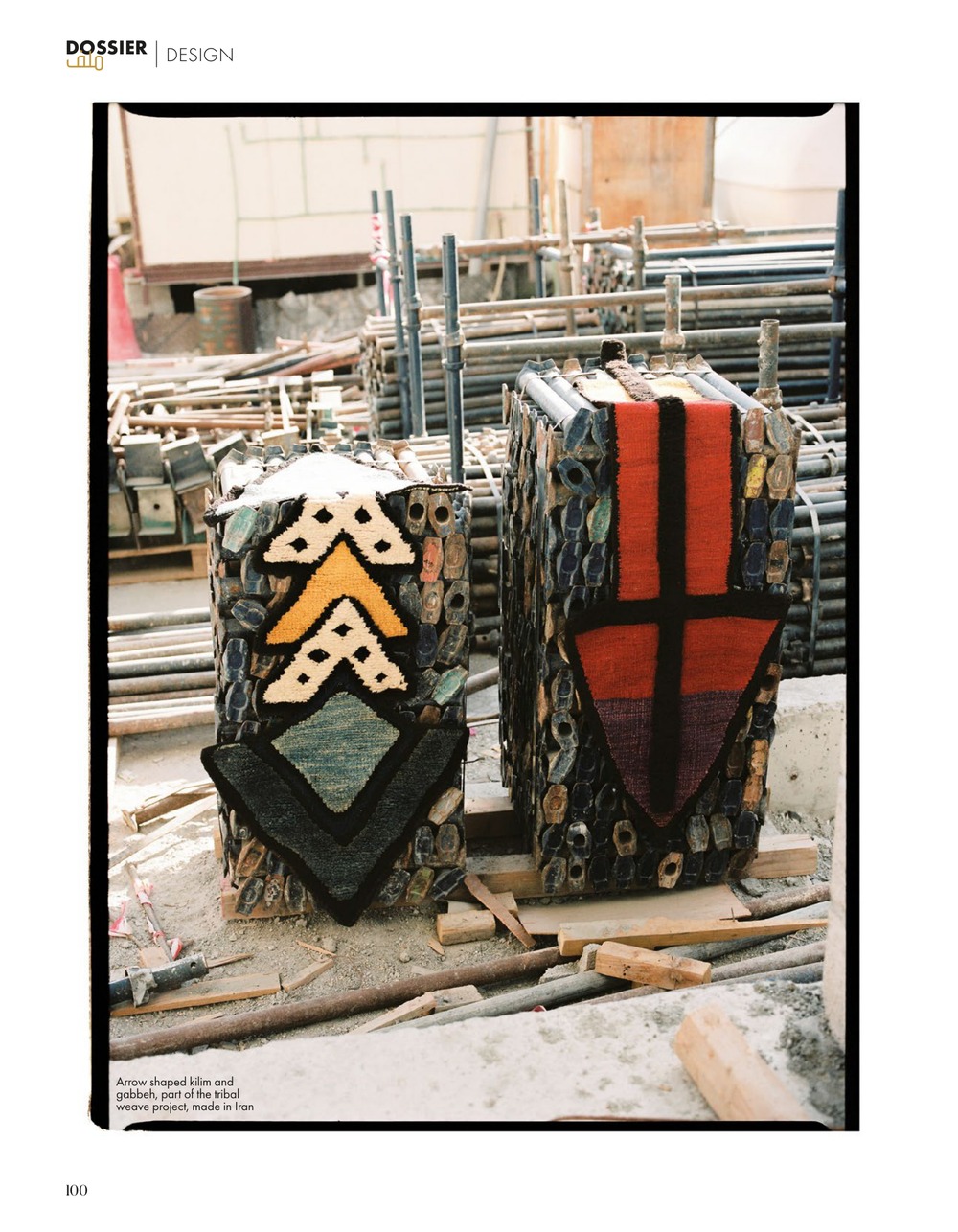 Two scaffold stacks wrapped in arrow-shaped kilim and gabbeh, one cream and gold, one red and black